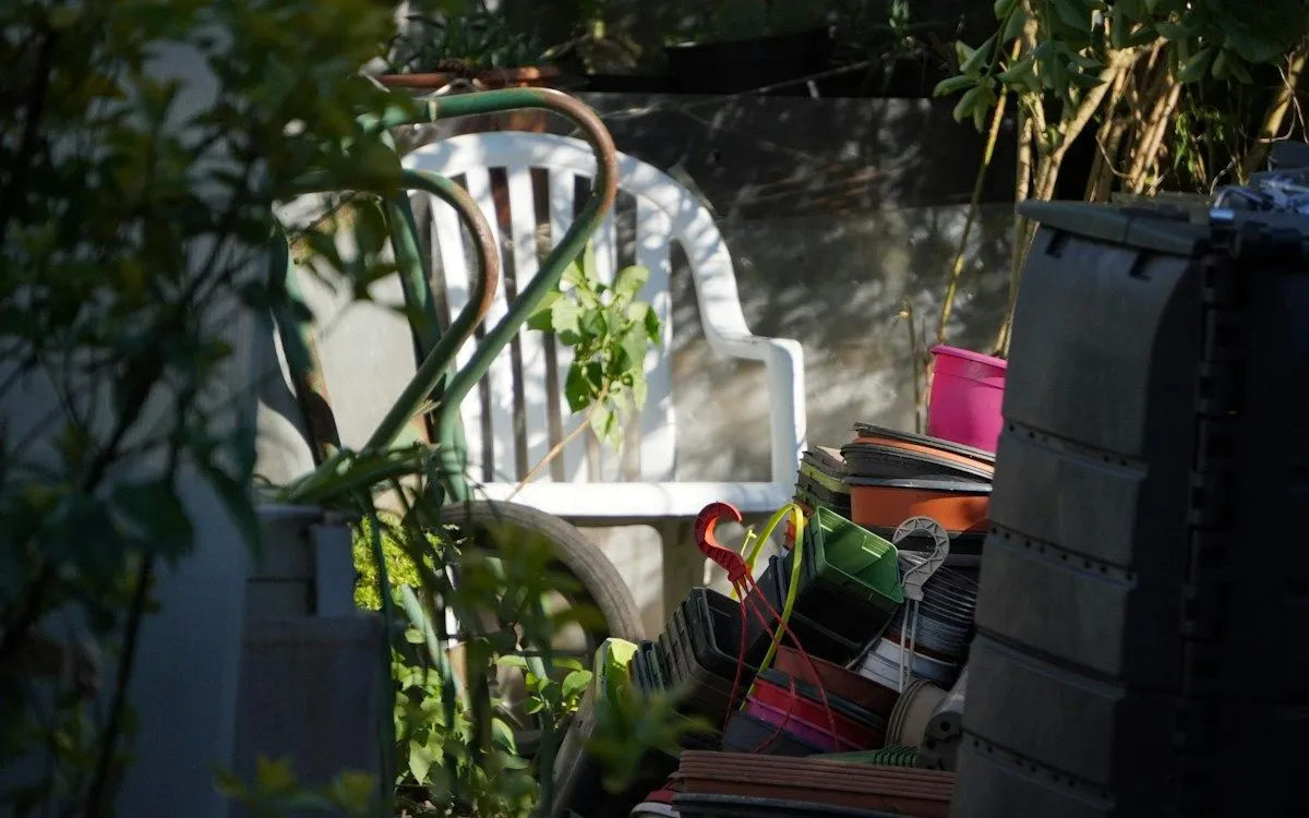 Un grillage à mailles fines posé au fond d'un composteur en bois vide, prêt à être rempli.